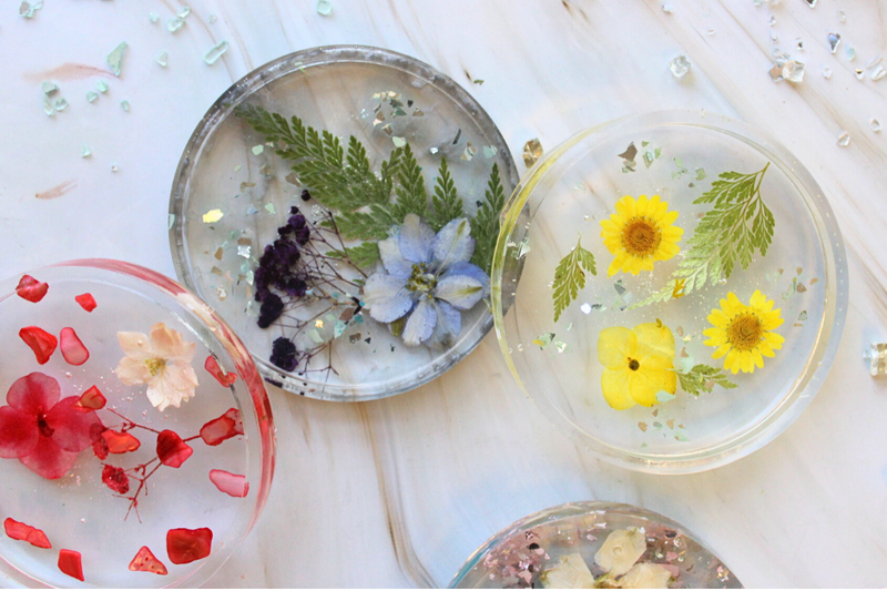 Decorative plates with pressed flowers and leaves on a light background